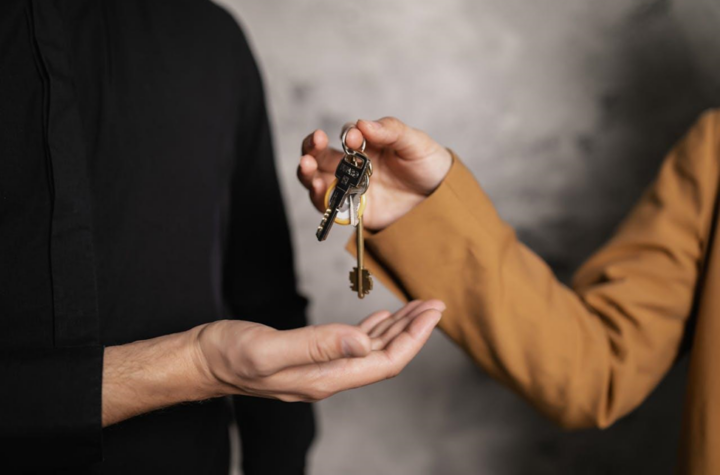 handing over the house keys to the new homeowner relocating to Tennessee