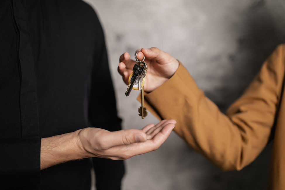 handing over the house keys to the new homeowner relocating to Tennessee